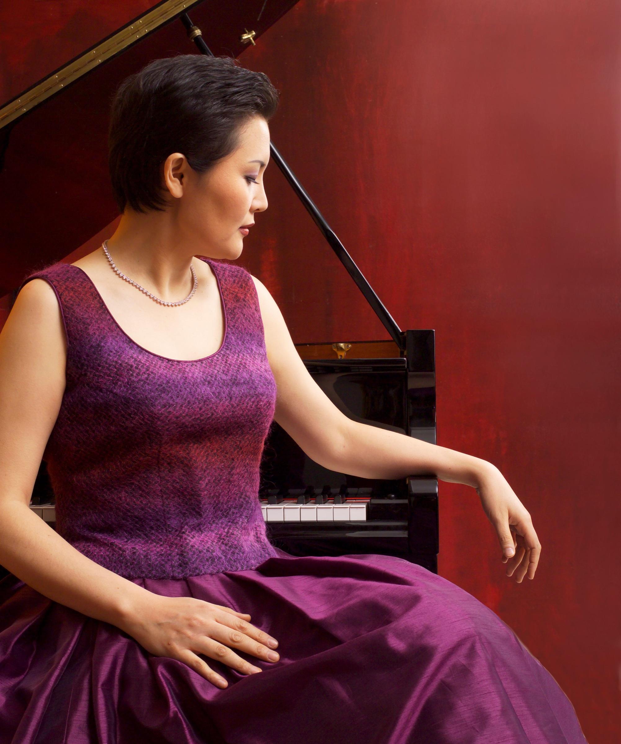 Mijung IM in a formal studio portrait at the piano